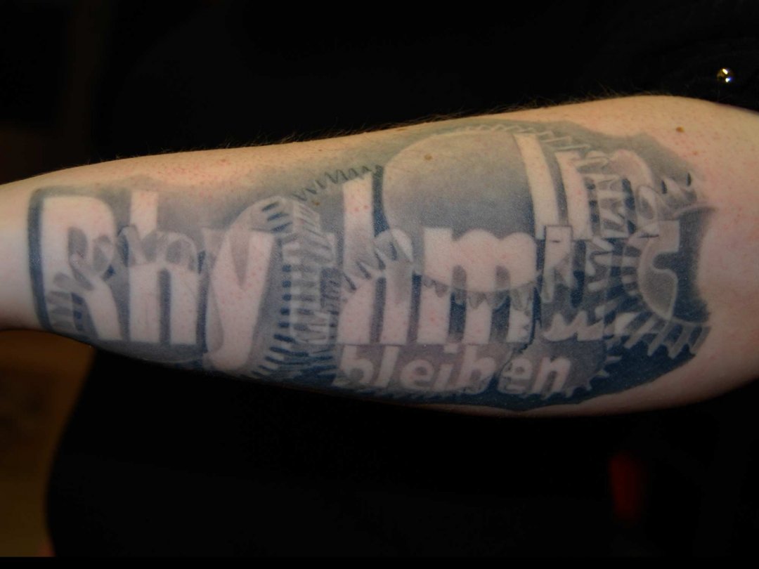 Biomechanik Zahnrad Tattoo mit Schrift