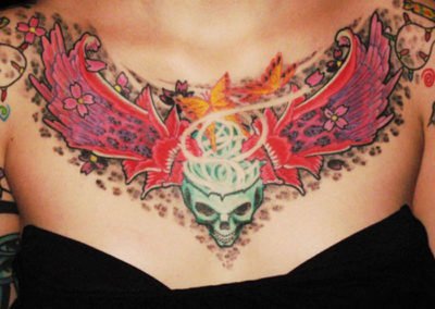 Dekolleté Schädel mit Blumen Tattoo und Leoparden Flecken