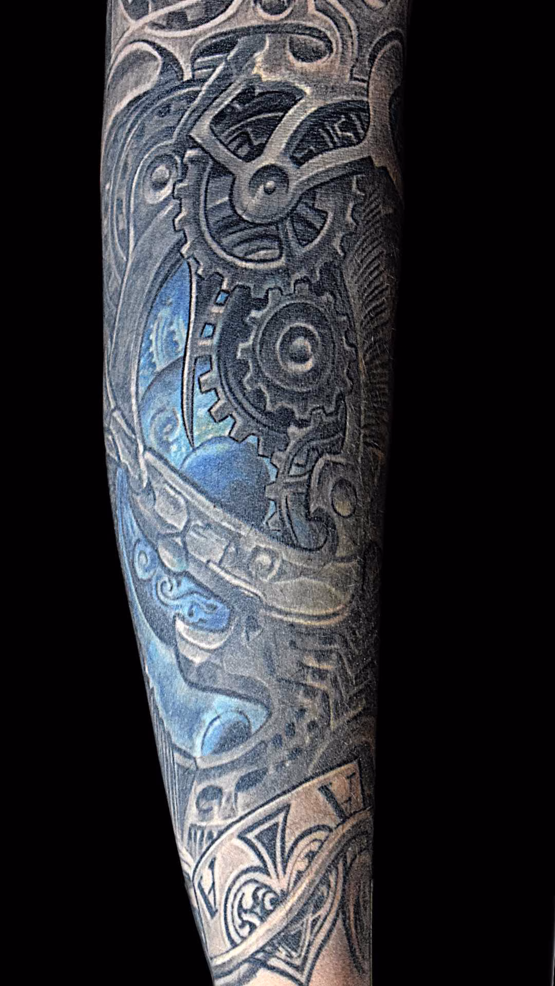 interaktiver Vergleich vorher nachher eines Cover-up Tattoo von einem Tattoo mit Ring um Mittelerde mit einer biomechanischen Zahnrad Auge Konstruktion danach
