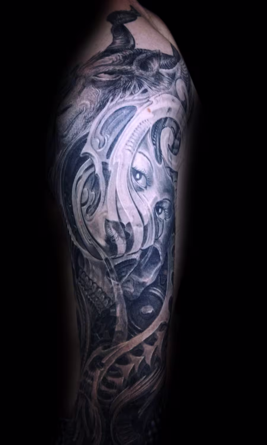 Biomechanik Sleeve Tattoo mit Zahnrad-Mechanik, Totenschädel und Frauengesicht, ergänzt durch detailreiche Ziegenbock-Elemente, Artist: Raul bei it for Life München