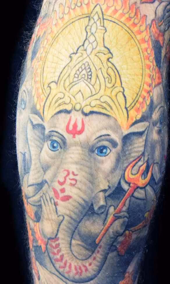 Spirituelles Trimukha Ganapati Tattoo mit drei Köpfen und 18 Armen, detailreiche Darstellung des dreigesichtigen Elefantengotts von Raul bei Hits for Life München.