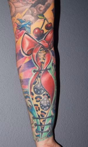 Rockabilly Old-School Tattoo mit Glaube-Liebe-Hoffnung-Symbolen, Schleife im Leopardenmuster, Würfeln und Kirschen, traditionelles Design von Raul bei Hits for Life München
