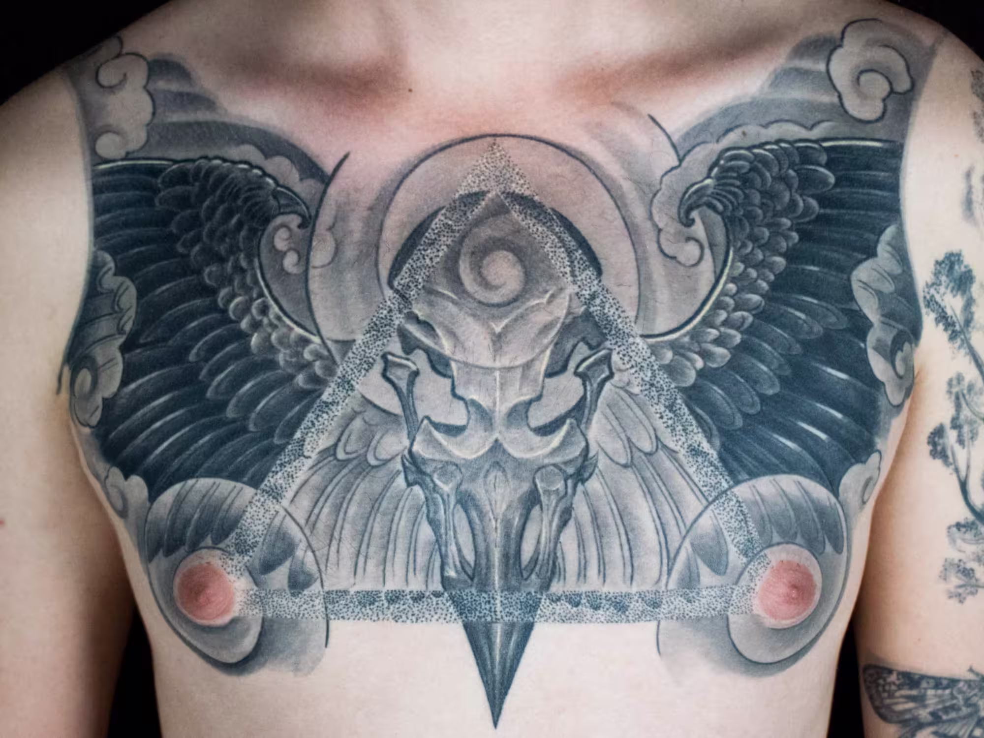 apanisch inspirierter Rabe im detailreichen Dotwork-Stil mit einem Totenkopf und geometrischem Dreieck, kunstvolles Tattoo von Raul bei Hits for Life München