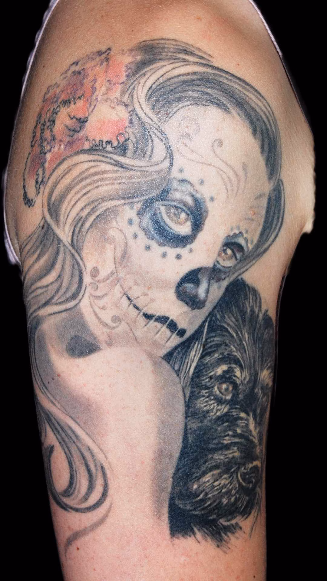 La Catrina La Catrina Tattoo mit Blick über die Schulter auf dem weiblichen Oberarm. Die Schulter der Figur dient als optischer Trenner zum dunkel gehaltenen Dackel-Portrait