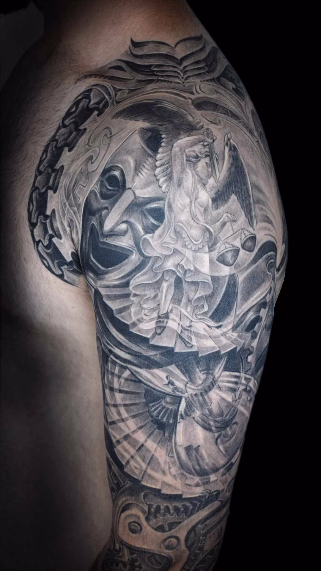 Erzengel St. Michael weinende Maske lachende Maske Stundenglas F Erzengel-Michael-Tattoo in hellem Grau auf dem Oberarm vor einer lachenden Maske, thronend über einer dunklen Sanduhr mit Wendeltreppe von Raul