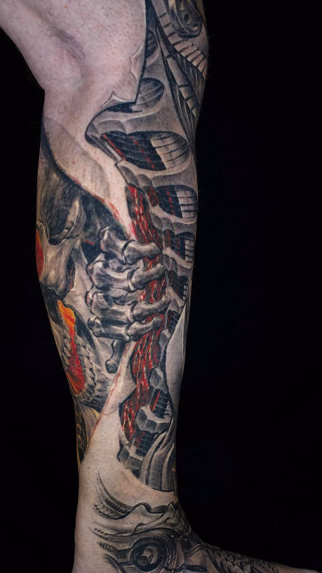 Biomechanik Leg Sleeve Biomechanik Leg Sleeve rechtes Bein: Skeletthand greift in aufgerissene Haut mit roter Muskelstrang-Mechanik am Außenknöchel