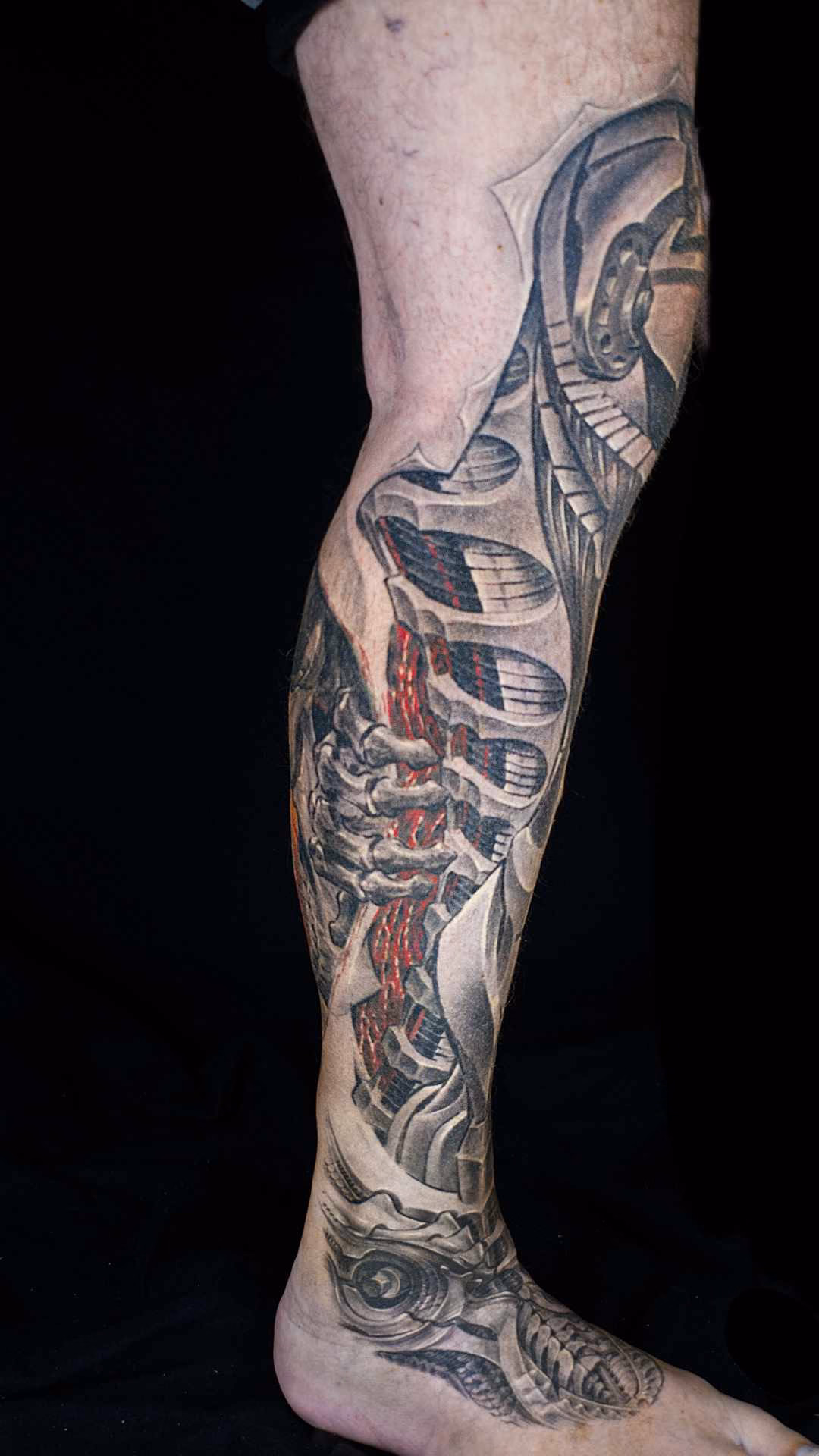 Biomechanik Leg Sleeve Biomechanik Leg Sleeve Gesamteinbindung: Schienbeinpanzerung trifft auf skelettierte Hand und roten Muskelaufriss am Außenknöchel