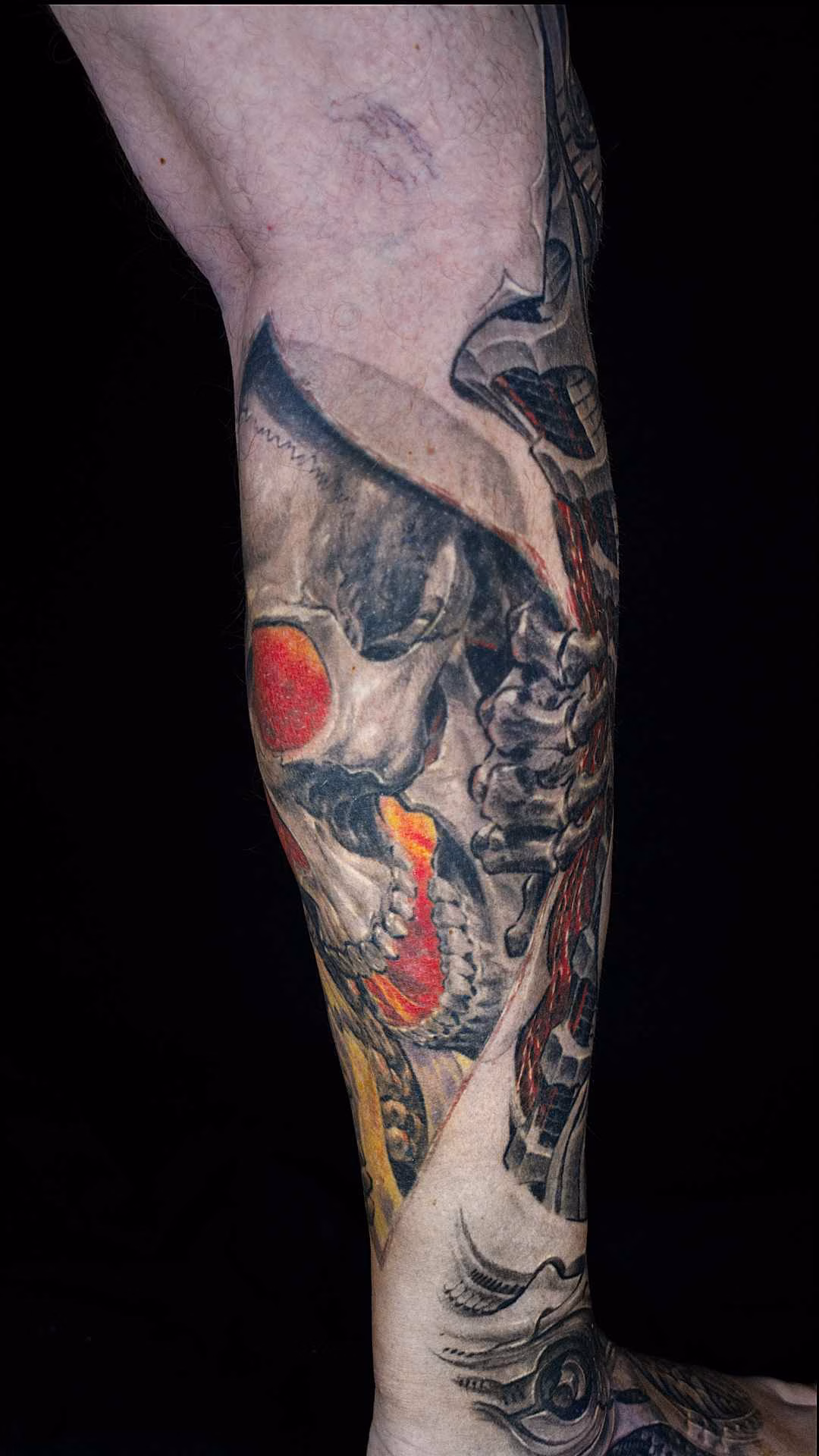 Biomechanik Leg Sleeve Biomechanik Leg Sleeve Detailansicht: Morbider Totenschädel greift in mechanische Risshaut mit offenliegenden Kabeln und Gewindeelementen