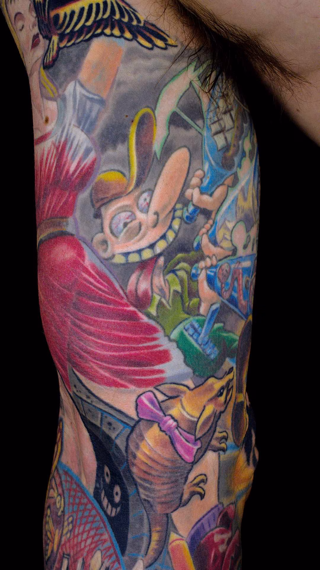 Flucht aus Berlin Tattoo Sleeve Wimmelbild Nietsche Historia in Detailansicht am Innenarm: Comic-Säufer nach Gerhard Seyfried mit Schnapsflaschen, Gürteltier mit rosa Schleife und farbenfrohen Wimmelbild-Motiven