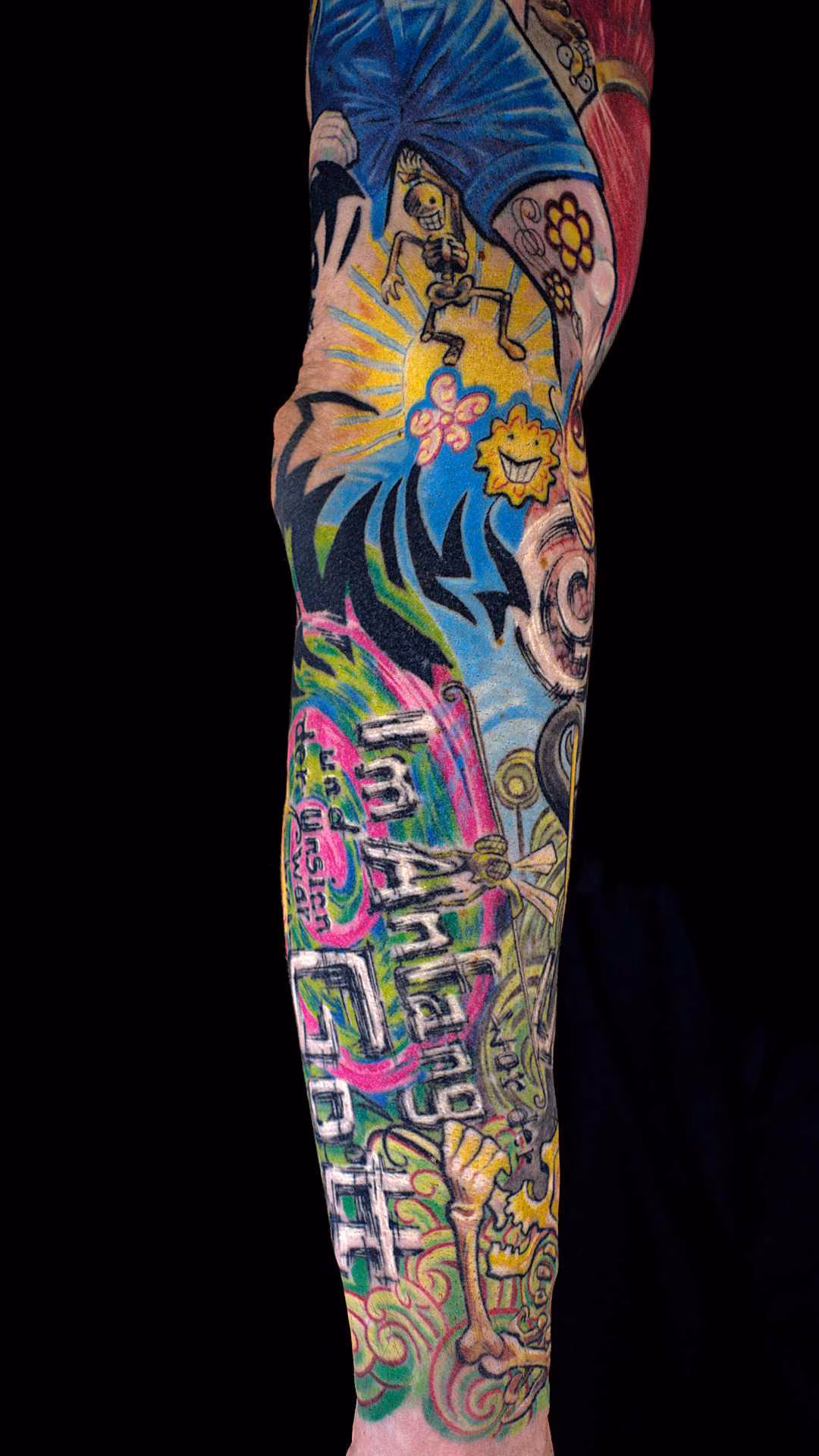 Flucht aus Berlin Tattoo Sleeve Wimmelbild Nietsche Historia in Unterarm-Tattoo mit dem Zitat „Im Anfang war der Unsinn“, gelber Sonnenszene und tanzendem Skelett vor leuchtendem Hintergrund – abgeheiltes Tattoo München
